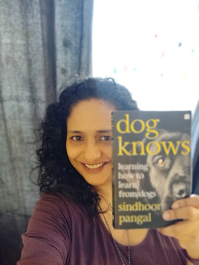 Sindhoor Pangal holding a copy of her book Dog Knows